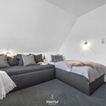 Schlafzimmer mit Schlafcouch und Einzelbett unter Dachschrägen.