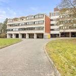 Modernes Mehrfamilienhaus mit Garagen und Grünanlagen.