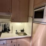 Küche mit Herd, Spüle, Mikrowelle und Küchengeräten.