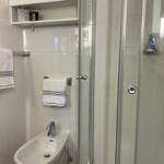 Badezimmer mit Dusche, Bidet und Handtuchhaltern.