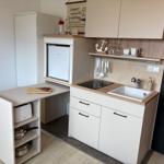 Küche mit Spüle, Herd, Kühlschrank und Arbeitsfläche