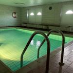 Innenpool mit Treppenstufen und Rettungsring an der Wand.