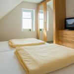 Schlafzimmer mit Doppelbett, Schrank und Fernseher