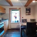 Küche mit Essbereich, Holzbalken und rotem Kühlschrank.