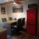 Esszimmer mit Tisch, Stühlen, rotem Kühlschrank und Fenster.