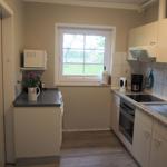 Küche mit Fenster, Spüle, Herd und Mikrowelle.