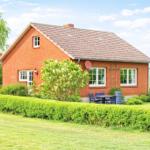 Rotes Backsteingebäude mit Garten, Terrasse und Sitzgelegenheit.