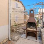 Outdoor area with grill and stone wall