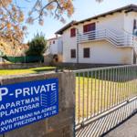 Private apartment building with balcony and garden area. Sign shows address.