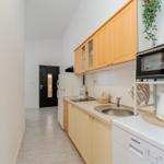 Kitchen with wooden cabinets, sink, refrigerator, and toaster oven.