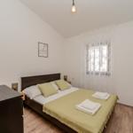 Bedroom with bed, nightstand, and window with curtains.