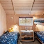 Zimmer mit zwei Betten, Holzwand und Fenster. Auf dem Bett liegen zwei gelbe Enten.