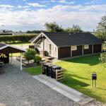Holzhaus mit Garten, Grillplatz und Parkplatz. Hinterhof mit Hecke und Bäumen.