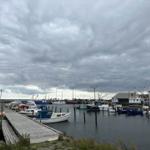 Hafen mit Booten und Steg unter bewölktem Himmel