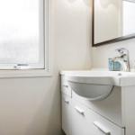 Waschbecken mit Spiegel und Fenster im Badezimmer