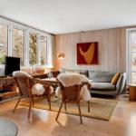 Wohnzimmer mit Sofa, zwei Stühlen und Fenstern zur Außenseite.
