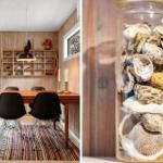 Esszimmer mit Holzwand und Tisch. Glasflasche mit Muscheln.