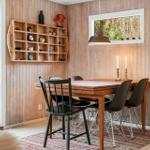 Esszimmer mit Holzwand, Tisch und Stühlen, Schrank und Fenster zur Außenseite.