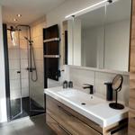 Moderne Badezimmer mit Dusche, Waschbecken und Spiegelschrank.