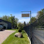 Ferienwohnung Ahrend mit Schild, Zaun und gepflastertem Weg.