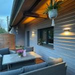 Terrasse mit Sitzgruppe, Tisch und Pflanzen unter Holzüberdachung.