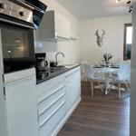 Moderne Küche mit Essbereich und Tisch für vier Personen.