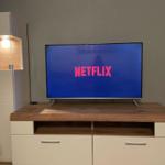 Flachbildfernseher auf Holz-TV-Möbel mit Netflix-Symbol