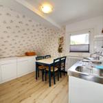 Küche mit Essbereich, Fenster, Spüle und Mikrowelle.