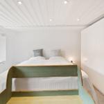 Schlafzimmer mit Bett, Fenster und Kleiderschrank.