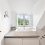 Badezimmer mit Waschbecken, Fenster und Spiegel