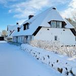 Schneebedecktes Fachwerkhaus mit Dach und Fenstern.
