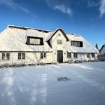 Schneefreie Dächer und weiße Fassade. Winterliche Szene mit schneebedecktem Grundstück.