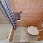 Badezimmer mit Dusche, Toilette und Handtuchhalter