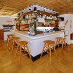 Barbereich mit Holzstühlen und Flaschenregal