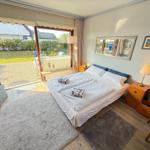 Schlafzimmer mit Doppelbett, Schreibtisch und Terrassentür.