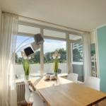 Essbereich mit Tisch, Stühlen und großem Fenster zur Terrasse