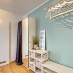 Raum mit Tür, Kleiderständer und Regal mit Körben.