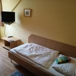 Ein Schlafzimmer mit Bett, Fernseher und Holzboden.