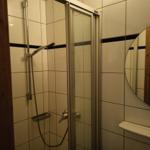 Badezimmer mit Duschkabine, Spiegel und Waschbecken