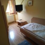 Schlafzimmer mit Bett, Fernseher und Fenster