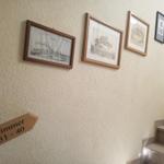 Wand mit Bildern und Schild für Zimmer 31 bis 40 neben Treppe