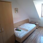 Schlafzimmer mit Dachschräge, Bett, Kleiderschrank und Nachttisch.