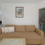 Wohnzimmer mit Sofa, Couchtisch und Wandbild. Durchgang zur Küche sichtbar.