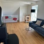 Wohnzimmer mit Holzboden, Sofa und Kamin