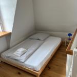 Ein Schlafzimmer mit einem Bett, einem Nachttisch und einer Lampe.