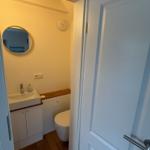 Badezimmer mit Waschbecken, Spiegel und Toilette