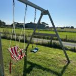 Schaukeln im Garten mit Blick auf Weide und Bauernhof.