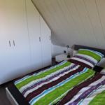 Bedroom with double bed, wardrobe, and sloped ceiling.