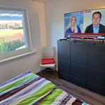 Bedroom with bed, window, and TV on cabinet