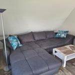 Gray corner with sofa, table, and floor lamp in attic room.